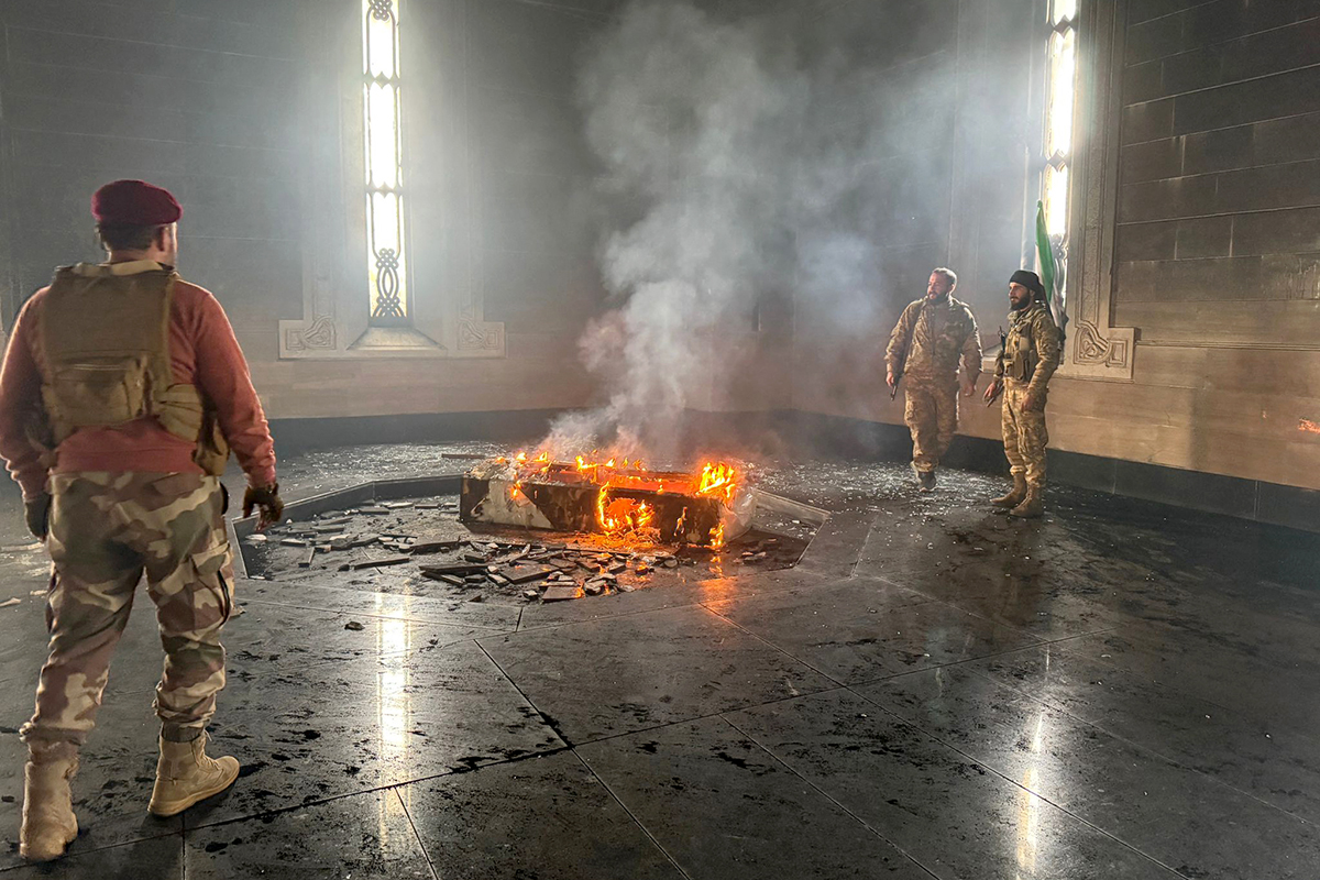 Ur askan ska något nytt växa fram. Exdiktatorn Hafiz al-Assads grav bränns. Foto: AFP/TT